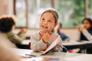 Excited little girl learns to draw with a colour pencil in an art class - YOUR GREEN ADVOCATE Kindschaftsrecht